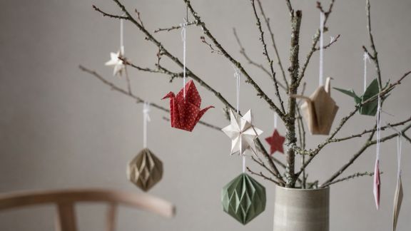 Décorer des branches d'arbre avec des suspensions en origami pour Noël